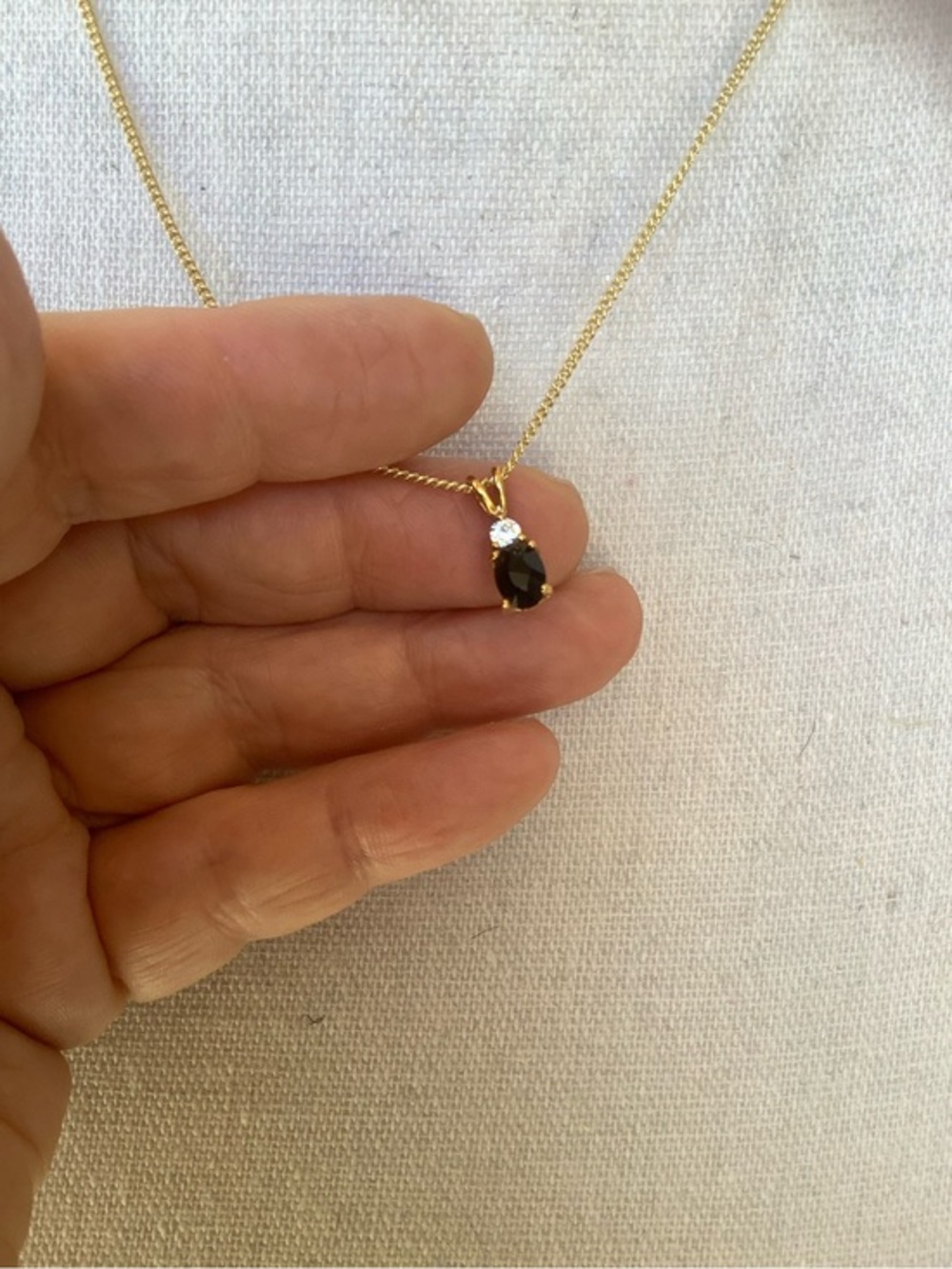 Solitaire pendant hangs on a Gold Plated necklace
